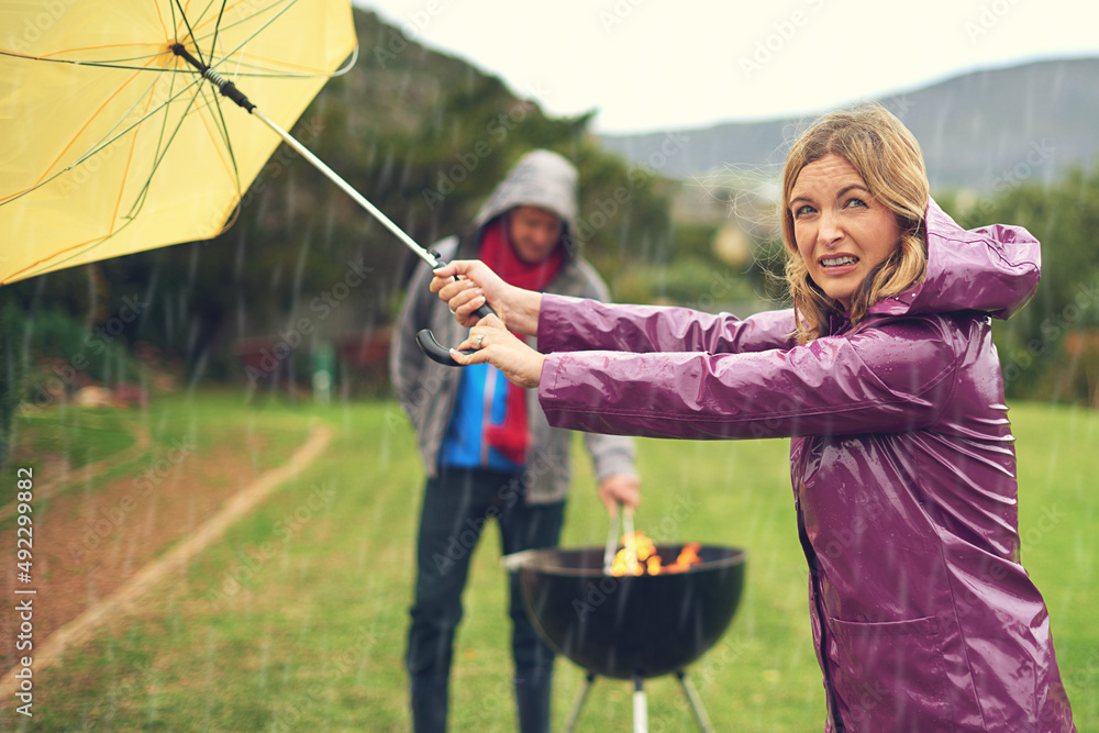 I think its clearing up. Shot of a couple trying to barbecue in the rain.