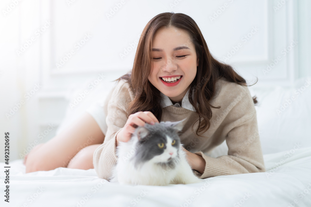 亚洲年轻女子在家玩猫