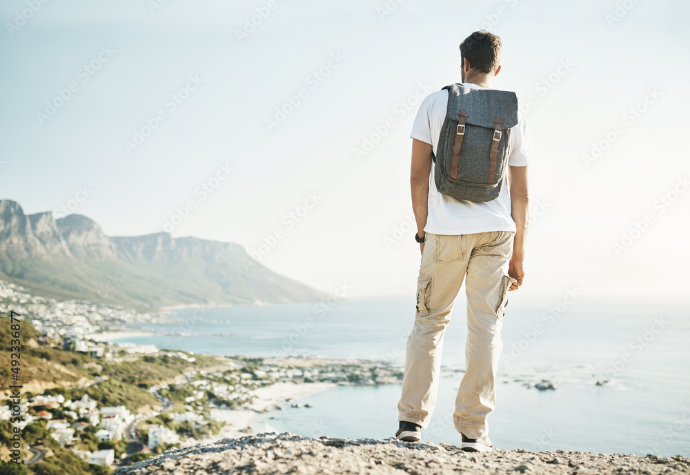 Taking time to admire the view. Rearview shot of an unrecognizable young man taking in the views whi