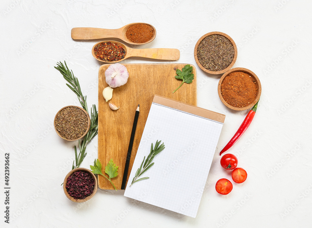 Composition with blank notebook, spices and vegetables on light background