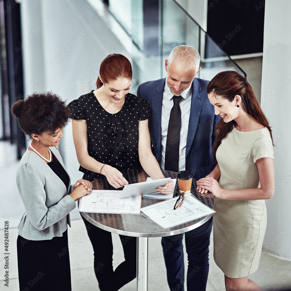 Running their business meeting on a new app. Shot of a corporate business team using a digital table