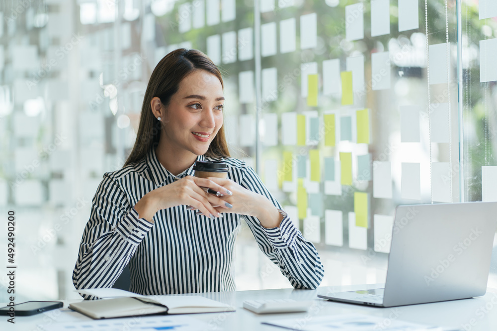 Businesswoman at workplace in office portrait during break drinks coffee from white cup smiling and 