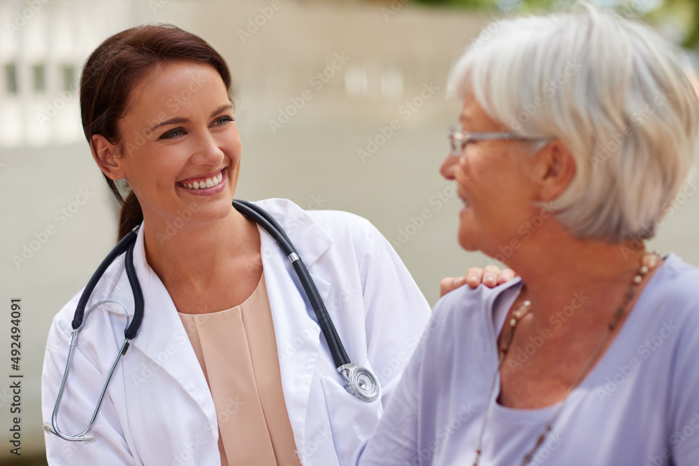 Kind and caring professional. Shot of a smiling doctor conversing with a senior patient.