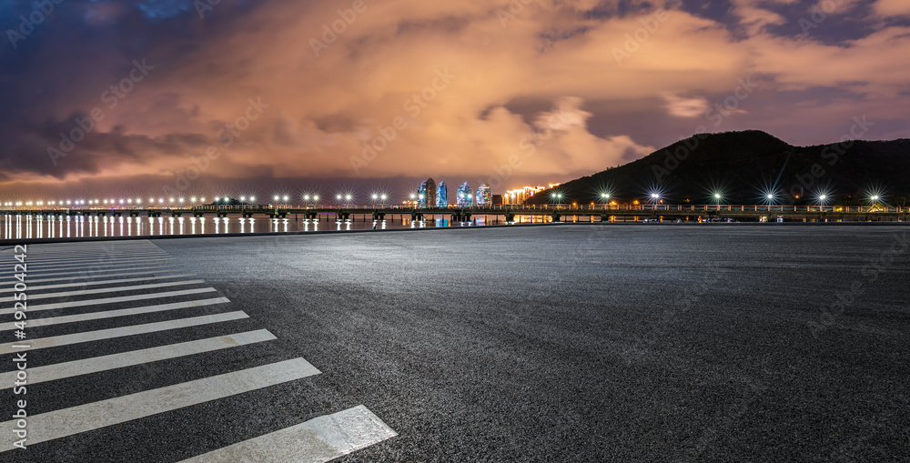 空旷的柏油路平台和夜晚云雾缭绕的山峰