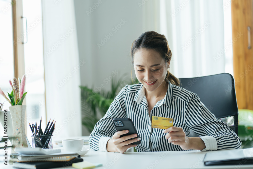 亚洲女性使用信用卡借记卡智能支付交易在网上购物零售店电子商务