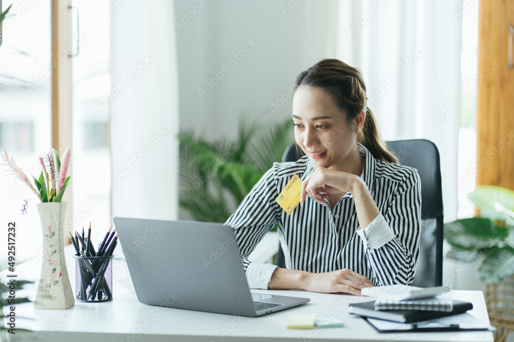 亚洲女性使用信用卡借记卡智能支付交易在网上购物零售店电子商务