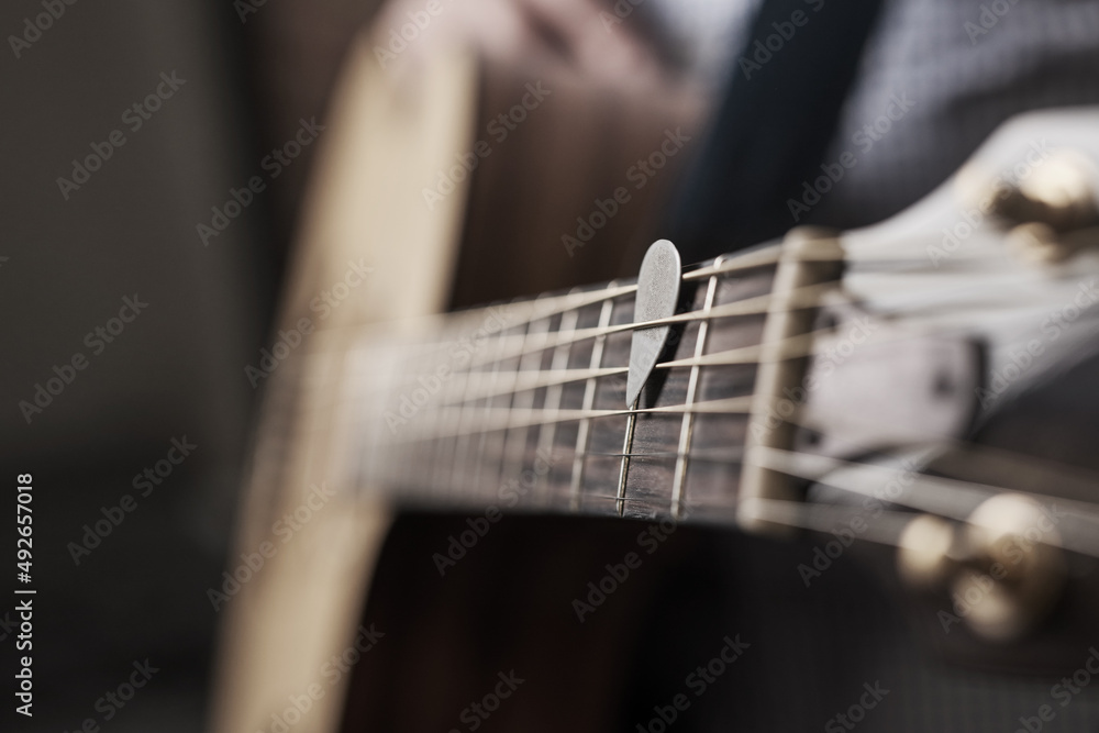 Pick up the tune. Cropped shot of an unrecognizable man playing an acoustic guitar at home.