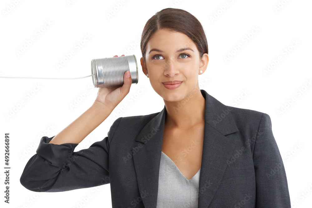 Old-school communication. Studio shot of an attractive young businesswoman listening to her tin can 