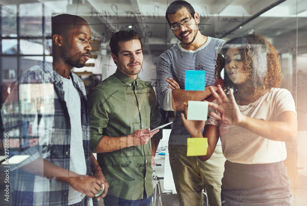 Their success is based on teamwork. Cropped shot of a group of young designers planning on a glass b