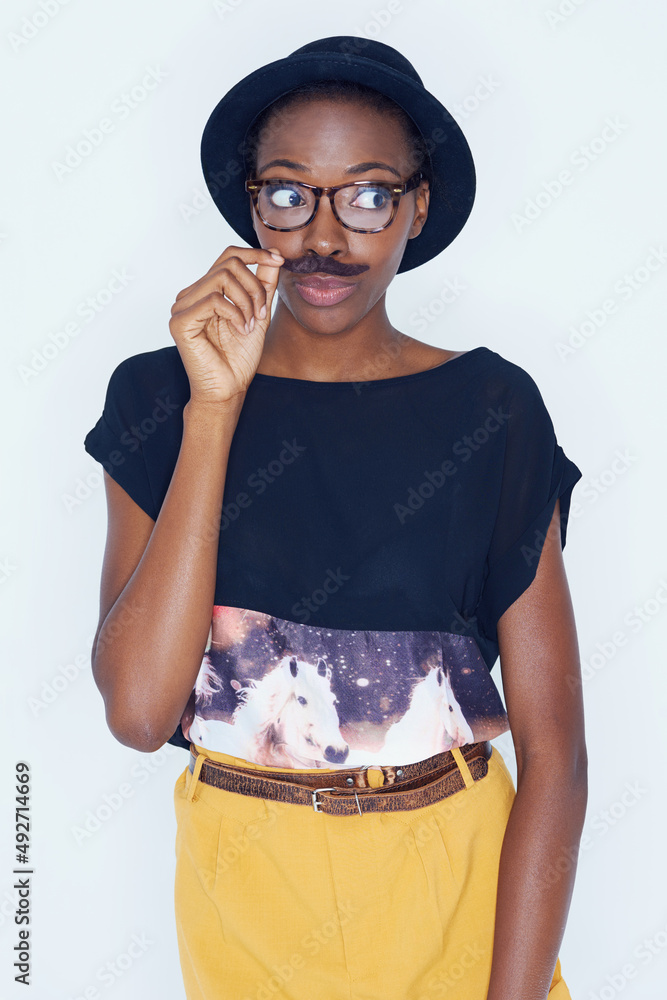 Expressing her childlike side. A young woman posing against white.