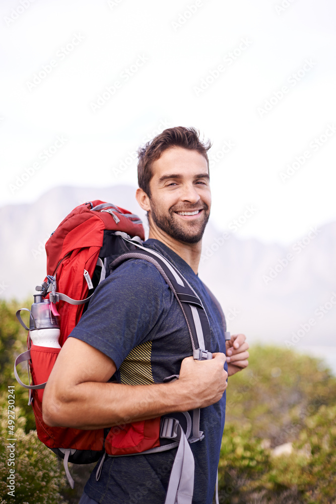 Feeling on top of the world. Shot of a young man enjoying a hike through the mountains.