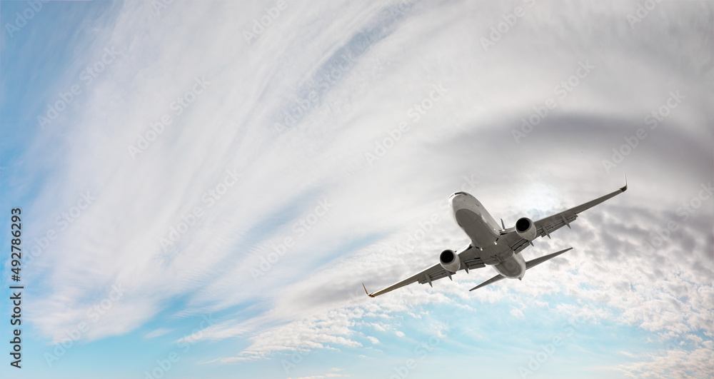 White passenger airplane flying in the sky amazing clouds in the background - Travel by air transpor