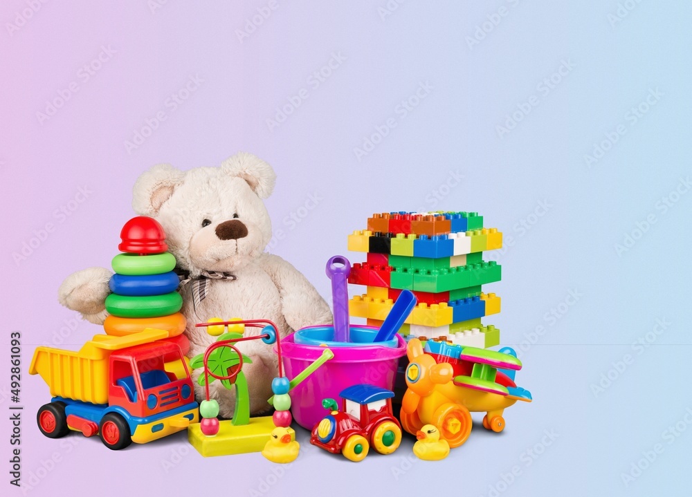 Cute kid toys. Container with bear, blocks on light background. Cute toys collection for small child