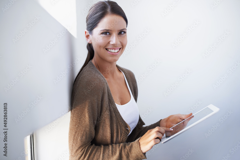 The tablet is so functional. A gorgeous young woman using her digital tablet in the office.