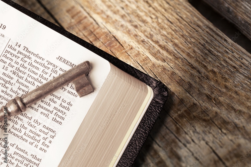 God Bible with an old, vintage key on a wooden table. Christian biblical concept of Jesus Christs g