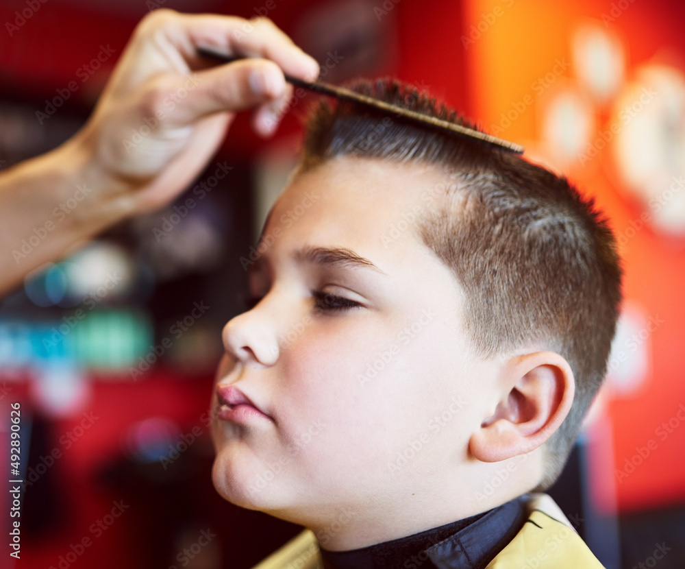 Looking good. Closeup shot of a young boy getting a haircut at a barber shop.