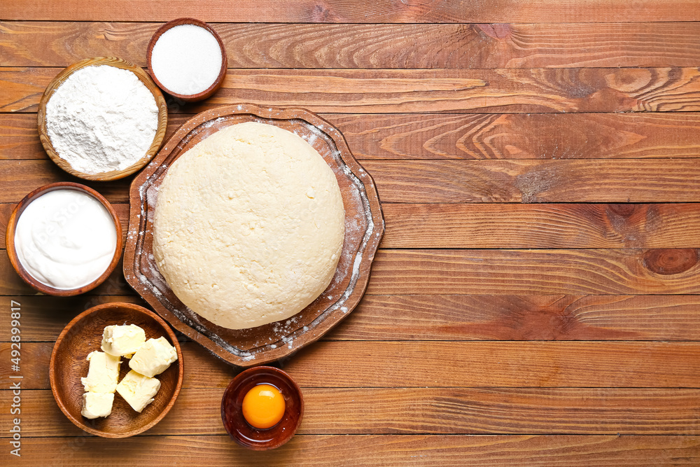 Composition with different ingredients for preparing lazy dumplings on wooden background