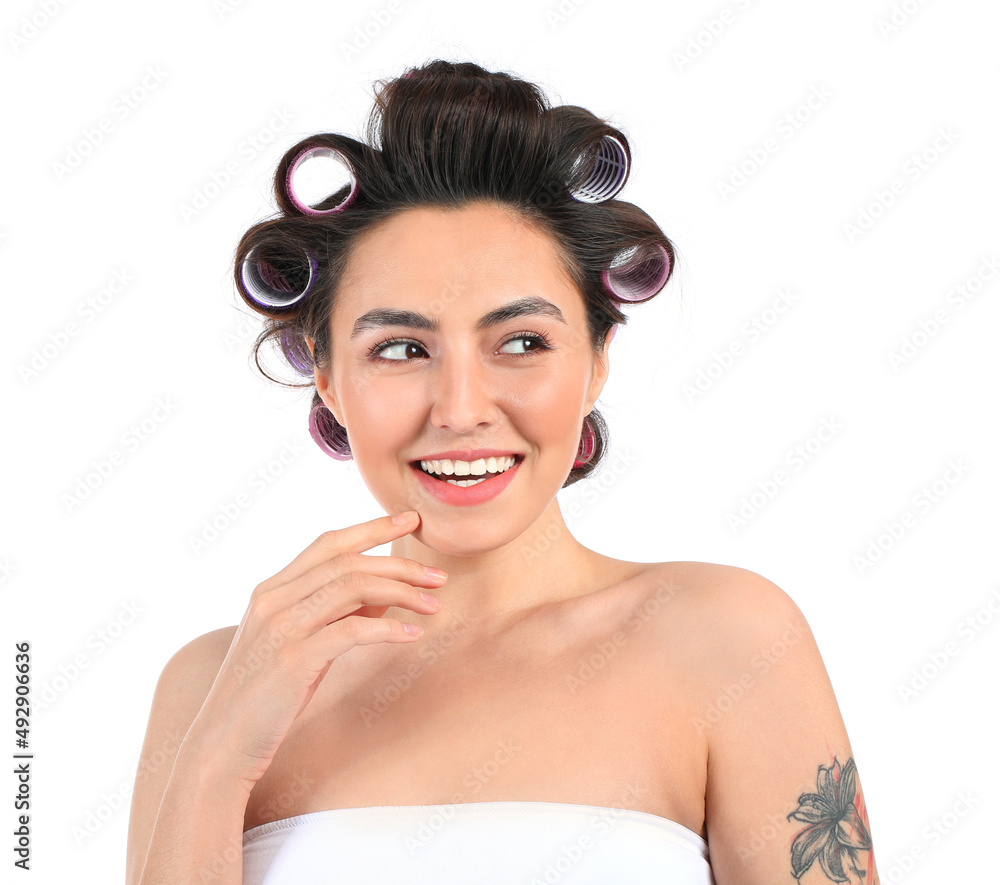 Happy young woman in hair curlers on white background