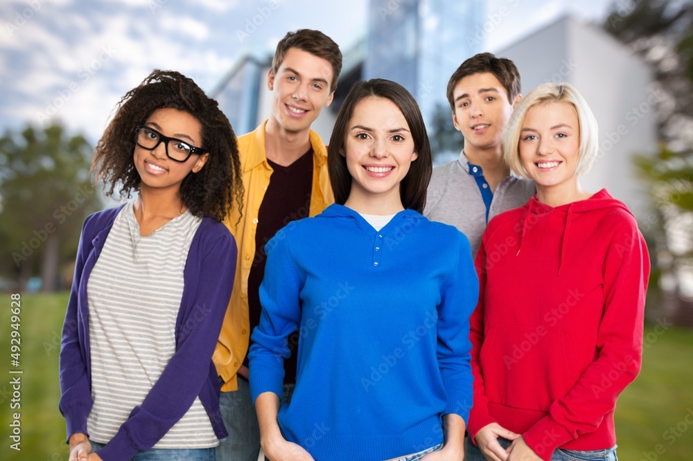 Education concept. Group smiling students with books and backpacks at walking in university campus.