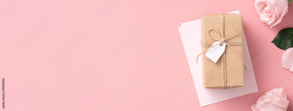 Mothers Day design concept background with pink rose flower and gift on pink background.