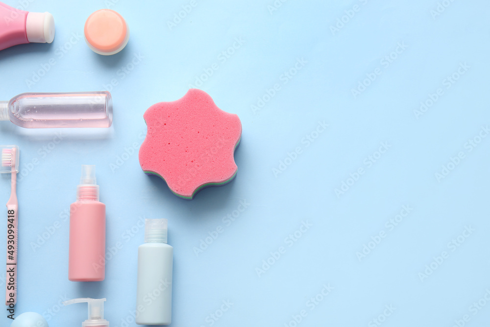 Different cosmetic products and bath sponge on color background