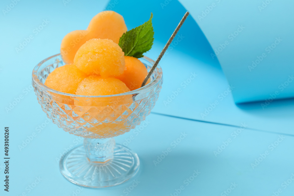 Bowl with tasty melon sorbet on blue background