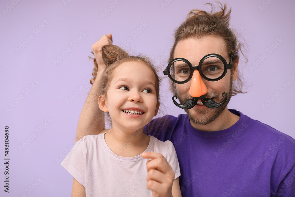 Funny man and her little daughter on lilac background. April fools day celebration