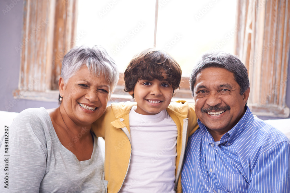 This is my second home. Two grandparents sitting on a couch with their grandson.