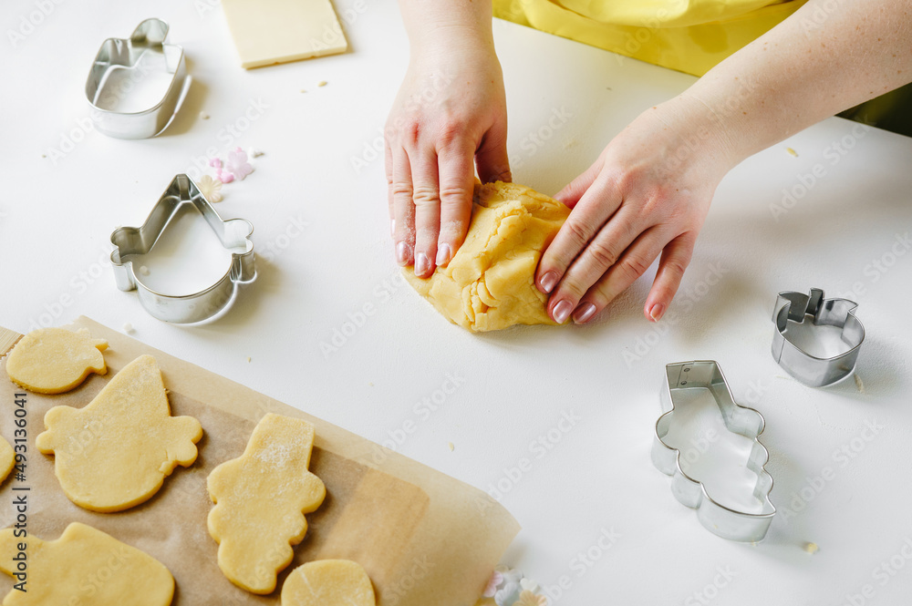 Female hands knead the pastry dough for sugar cookies in ice cream cone shape. Summer concept