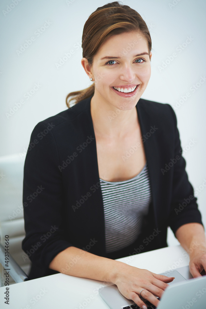 Its the perfect job for me. Studio portrait of a young businesswoman working on her laptop.