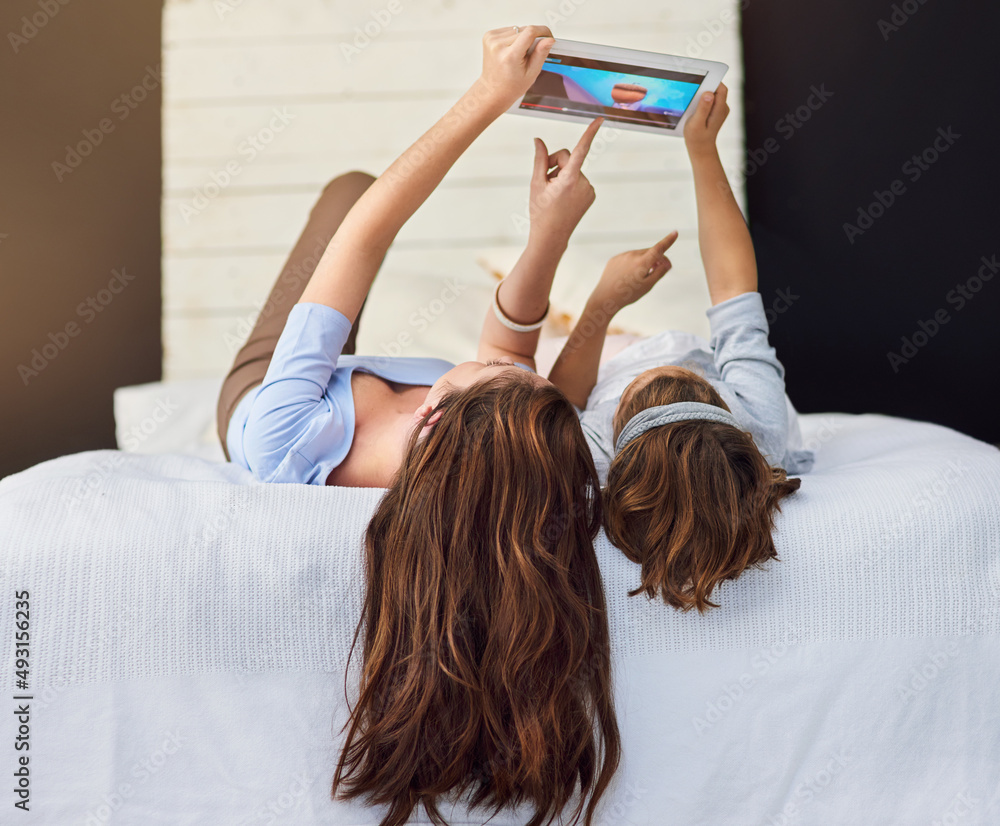 Look at that. Full length shot of a mother and her daughter using a digital tablet.