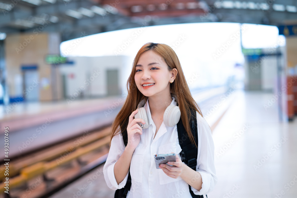 Young Asian girl waiting for the train at the station