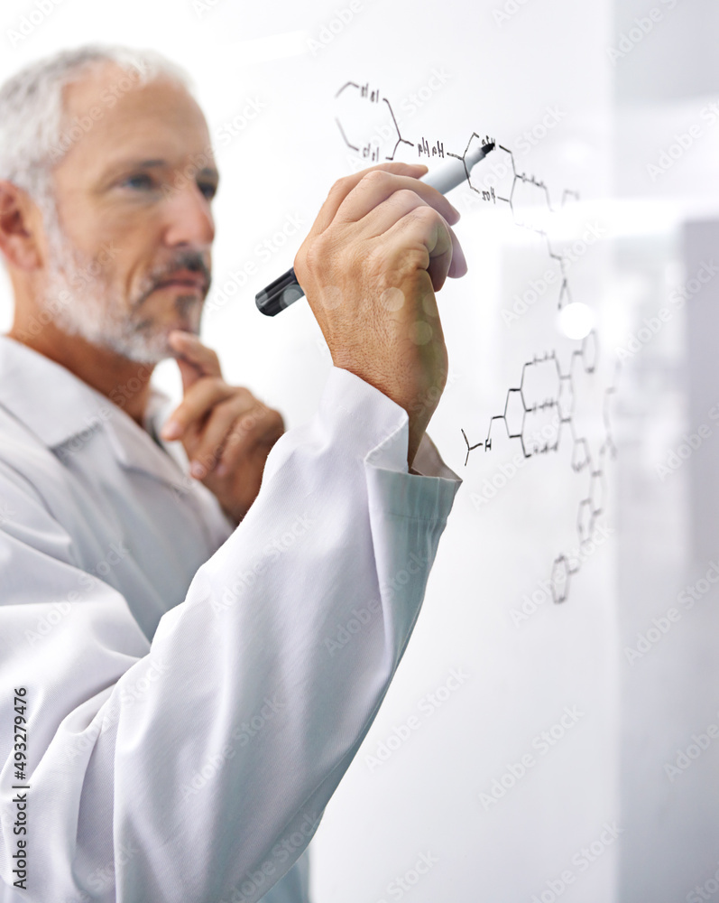 Hes involved in cutting edge research. Shot of a mature male scientist drawing a molecular structure