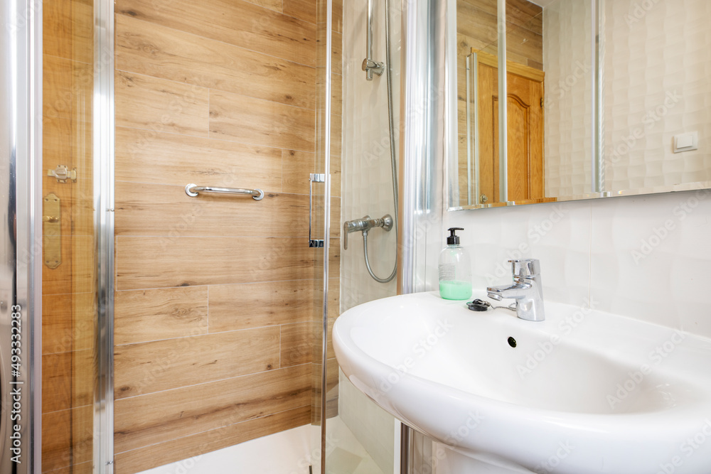 Bathroom with a white porcelain sink on a black wooden countertop, gray stoneware walls and red pain