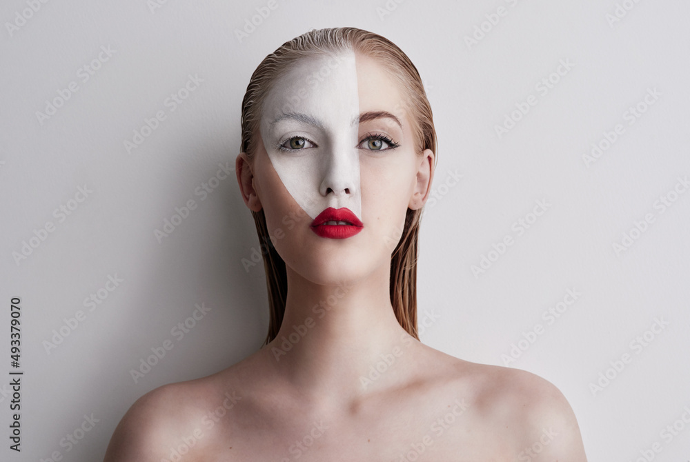 Put on some red lipstick and live a little. Shot of a beautiful woman wearing face paint and red lip