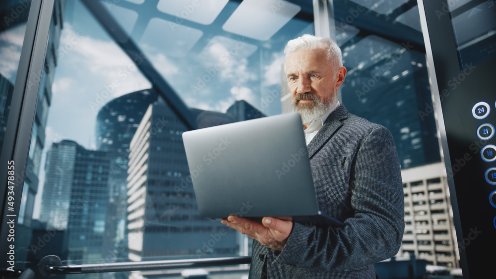 Successful Middle Aged Businessman Riding Glass Elevator to Office in Modern Business Center. Handso