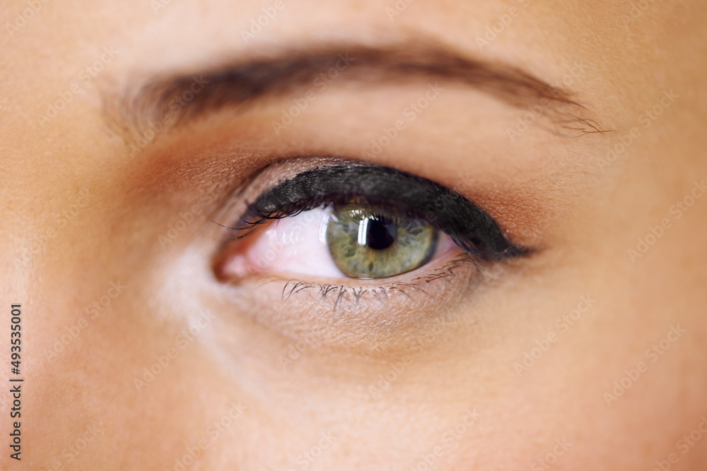 Beautifully made-up eye. Closeup of a vivid green eye with thick mascara-coated lashes.