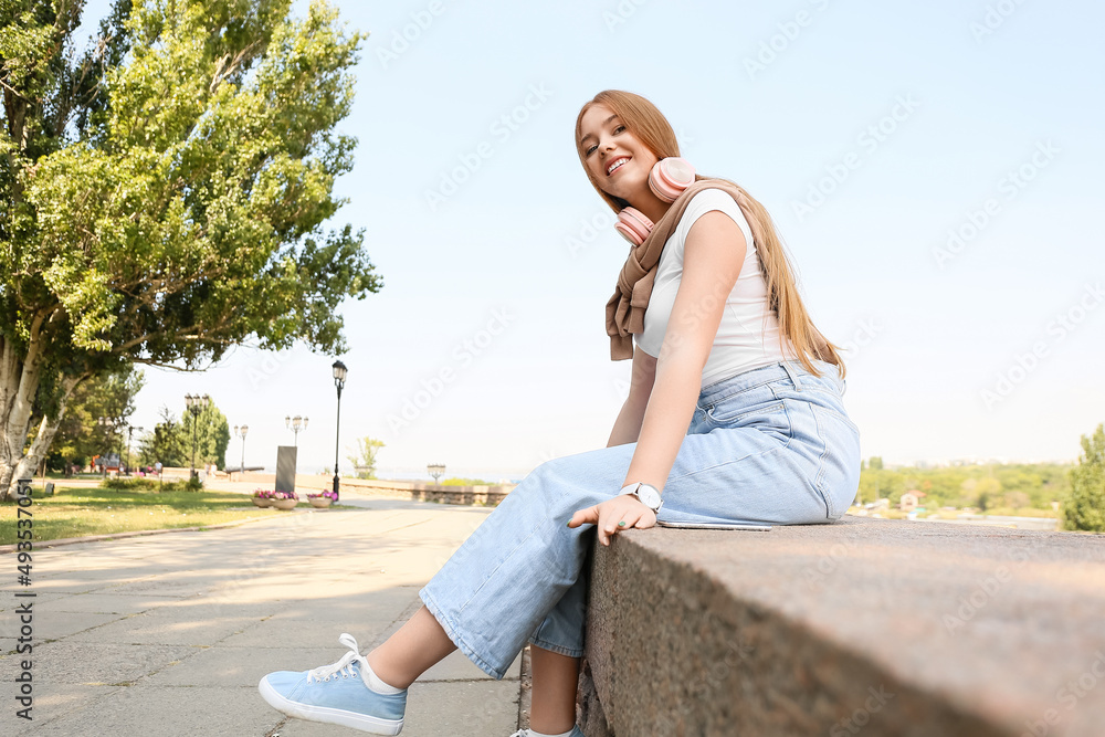 酷酷的年轻女子在户外听音乐