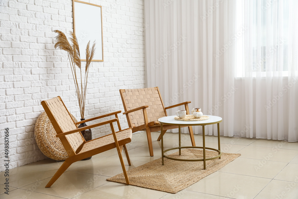 Interior of stylish living room with wooden armchairs and coffee table