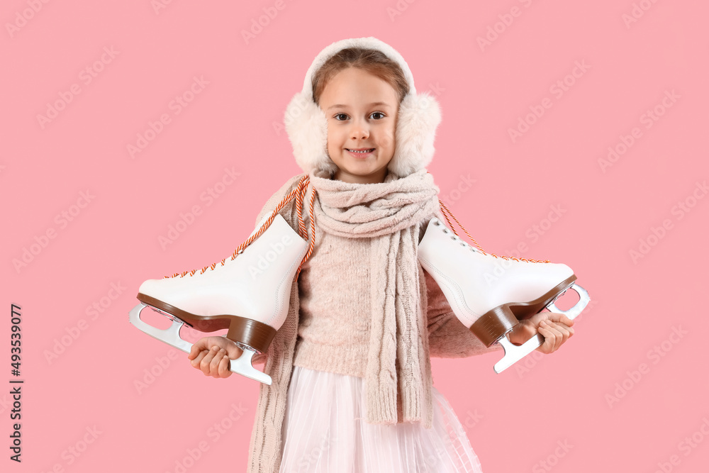 Cute little girl in winter clothes and with ice skates on color background