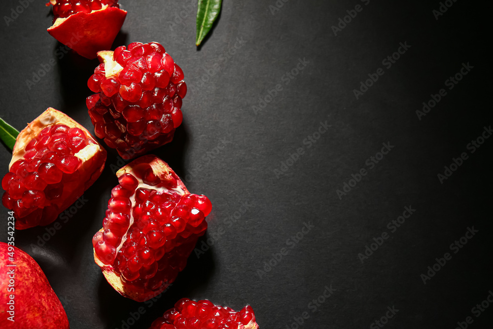 Tasty ripe pomegranate pieces on dark background