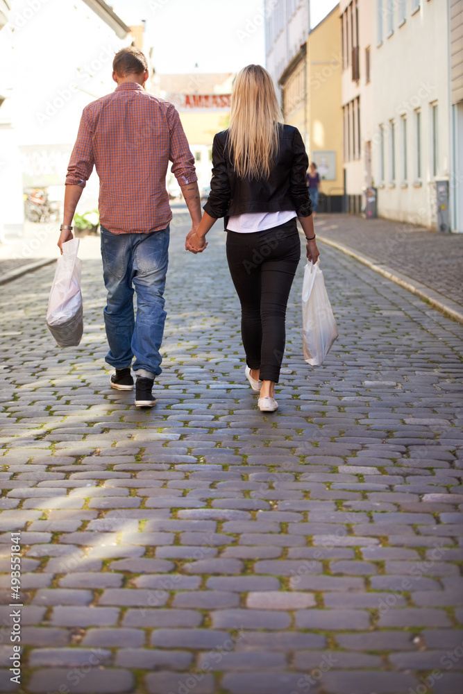 Hand in hand. A happy young couple walking hand in hand through the streets.