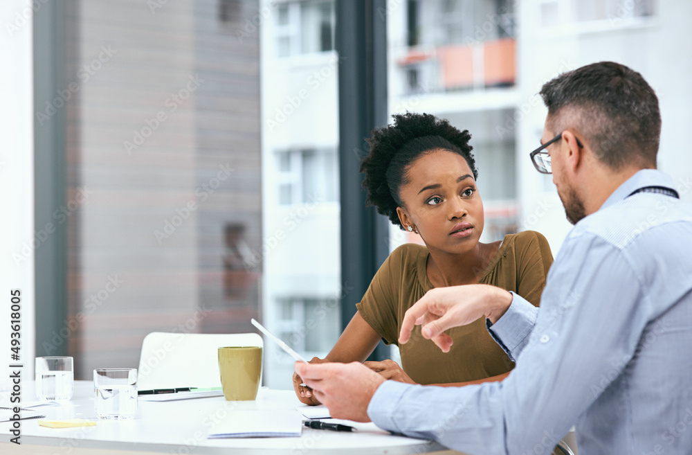 Weighing the pros and cons of their strategies. Cropped shot of two colleagues working together on a