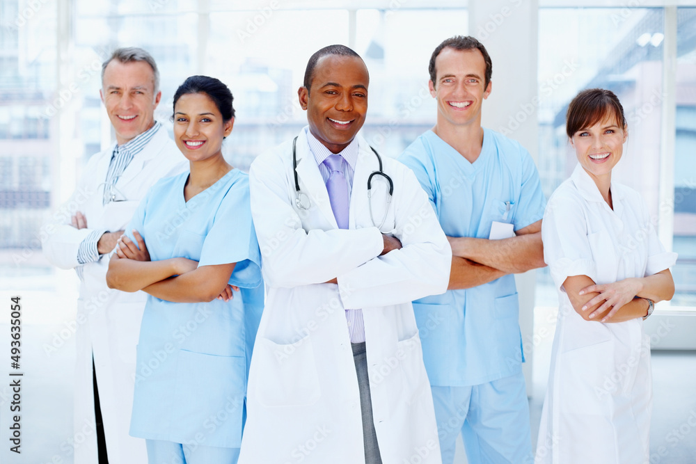 Doctor standing proud with his team. Doctor standing with his medical team.