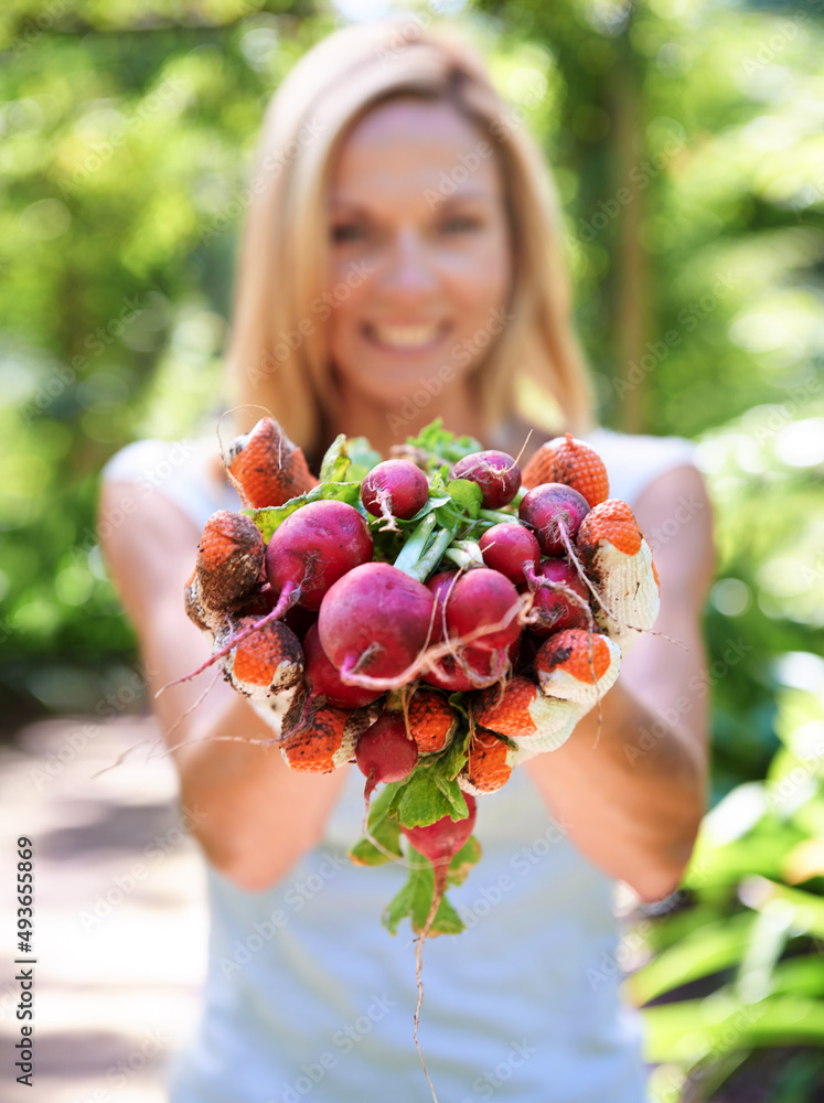 Heart health is in her hands. A woman holding out freshly picked vegetables.