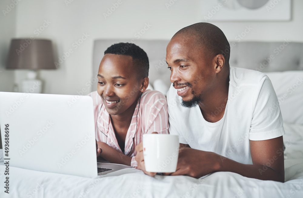 Whats home without an internet connection. Shot of a happy young couple using a laptop together in t