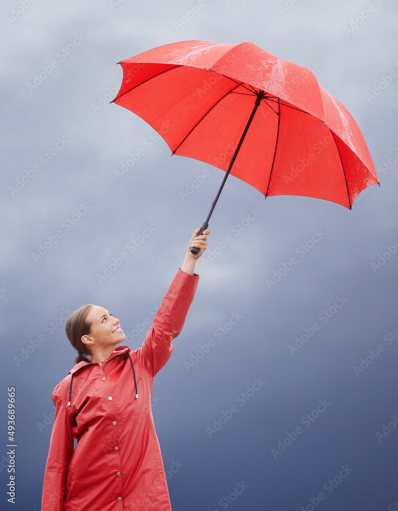 我知道我被遮住了。一个漂亮的年轻女人拿着她的红色雨伞站在外面。