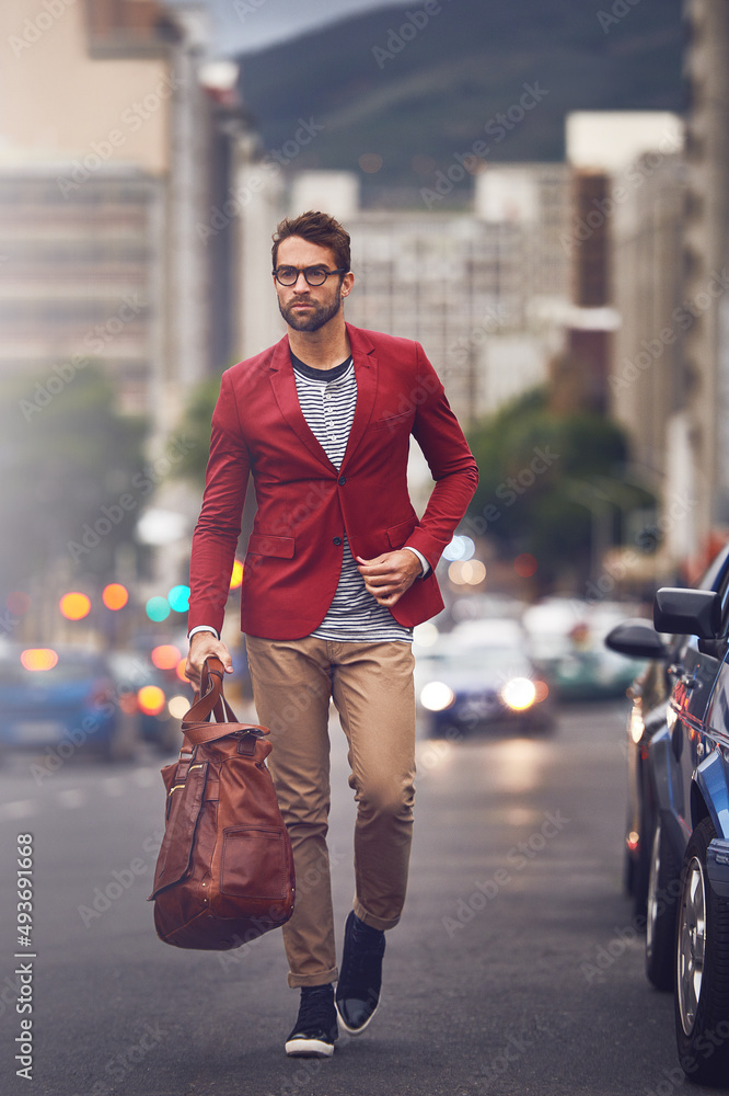 I will get there one way or another. Shot of a handsome young man walking in the road while carrying