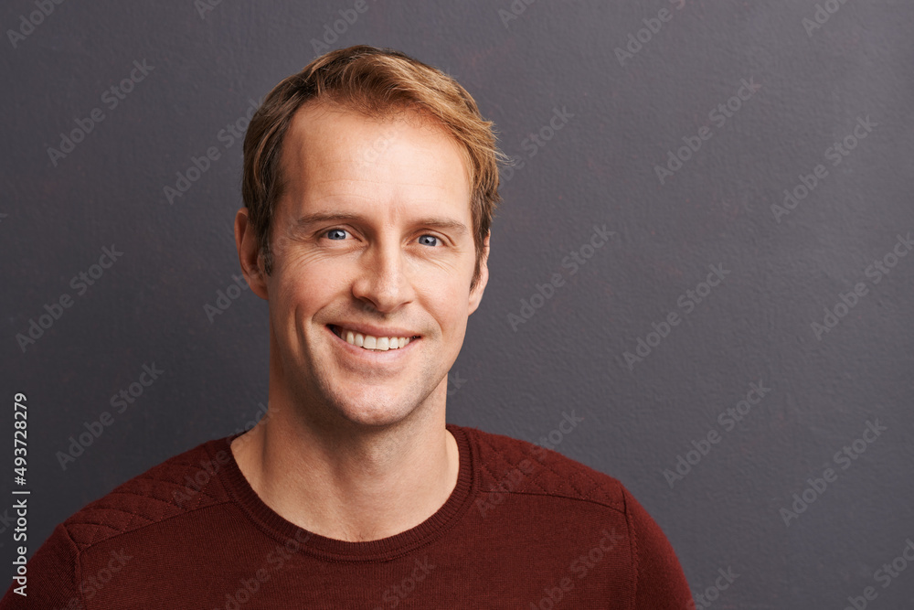 He knows how to turn his charm on. A studio portrait of a handsome man in a sweater.