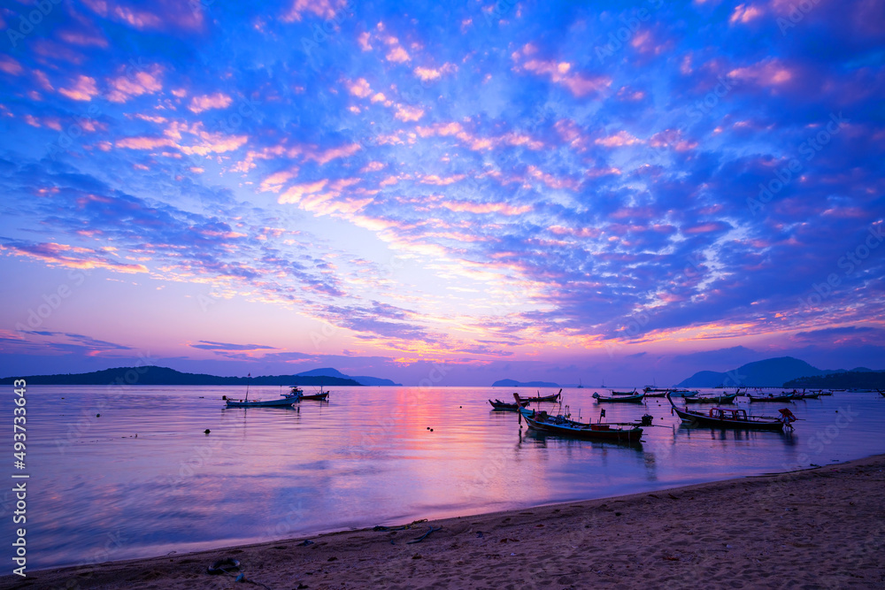 热带海洋中的长尾船和旅游船美丽的风景日出或日落天空